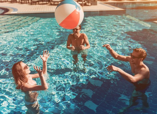 Compañeros de trabajo disfrutando en la piscina de una actividad de Team Building para desconectar y extremecer lazos